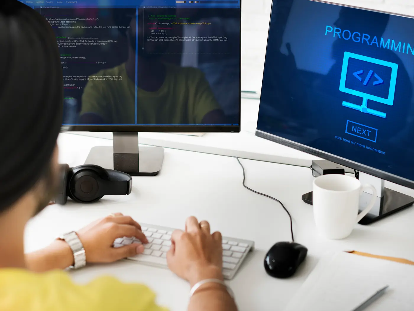 Developer writing SharePoint Framework code across two monitors